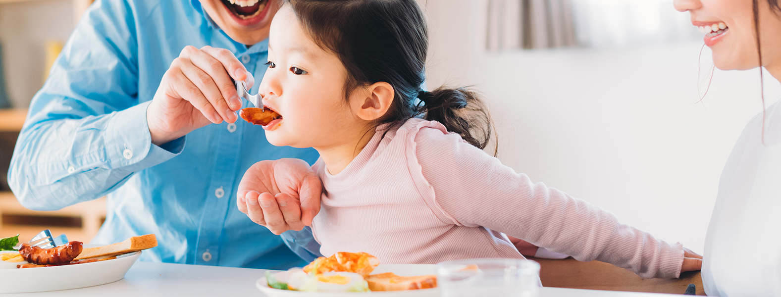 サンドイッチを食べる家族